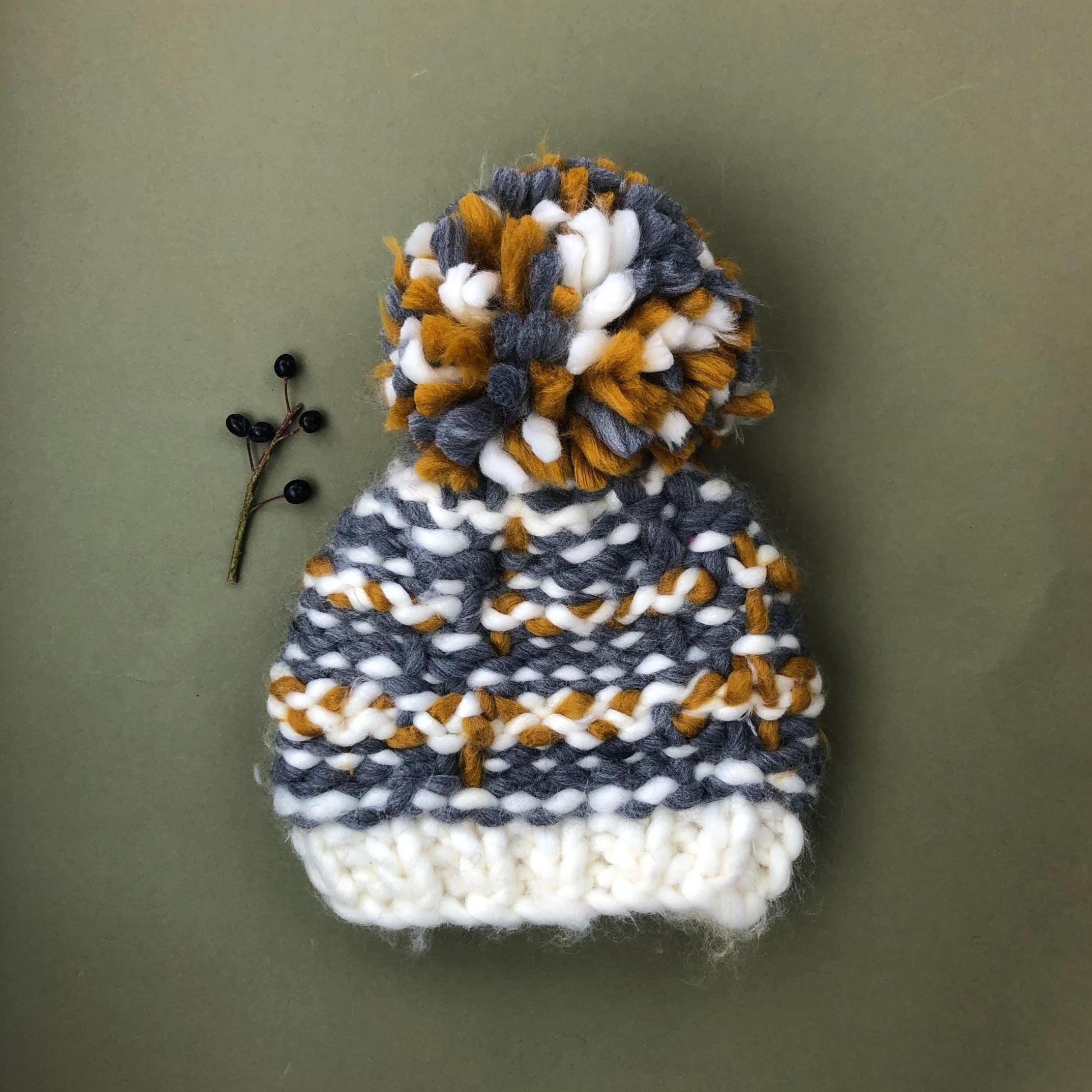 brown gray cream white hat with big fluffy pom hand knit for babies and small children outdoors