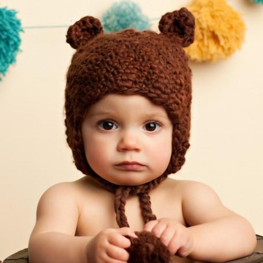 crochet bear hat with ears and pom tassels for baby and toddler brown