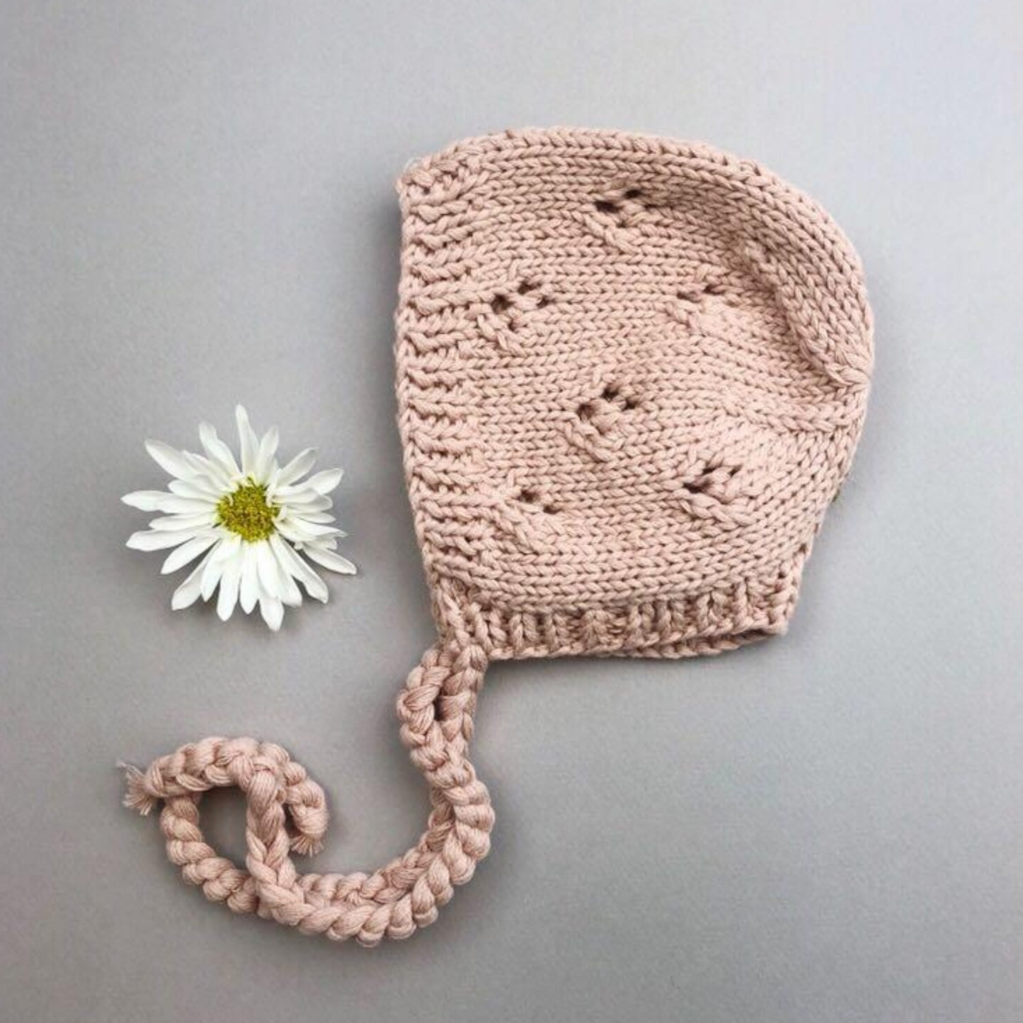 hand knit dusty pink cotton bonnet with openwork stitching and tie closure
