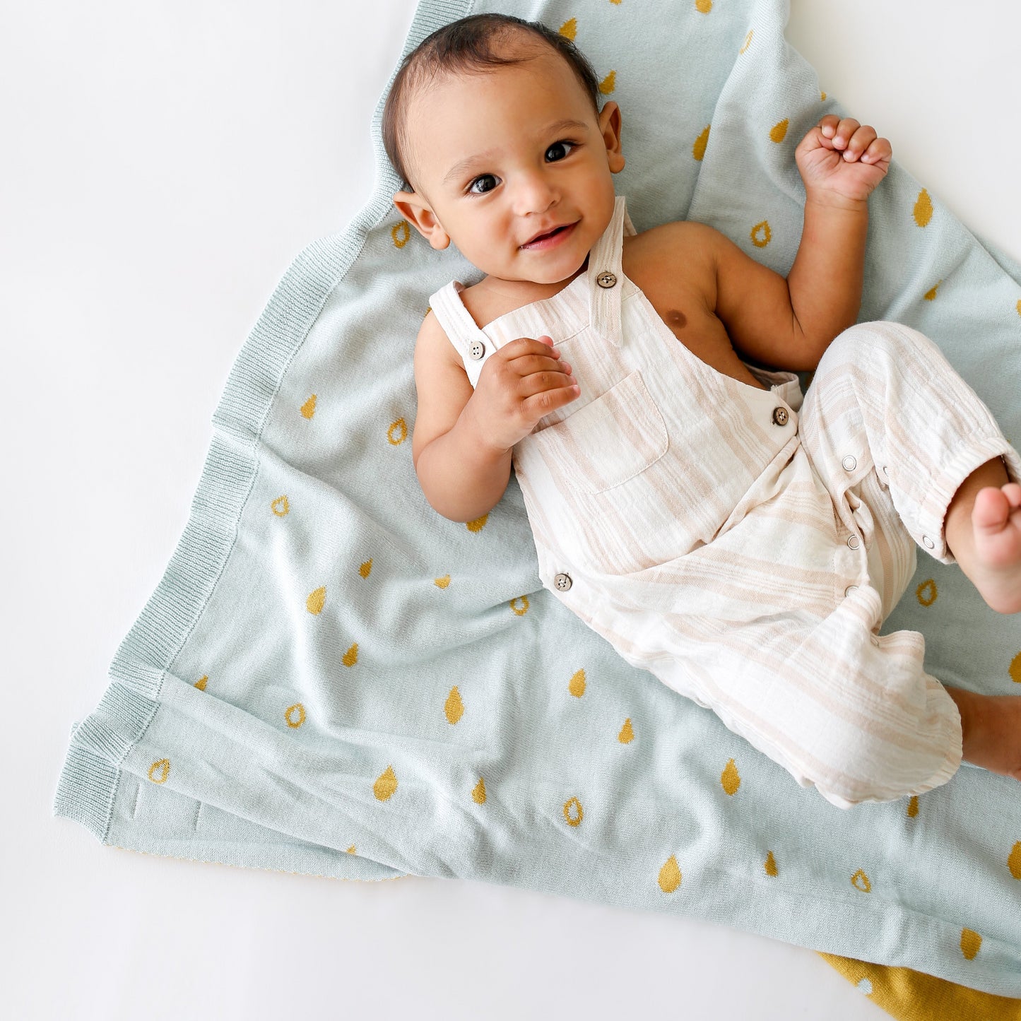 reversible gotc organic cotton blanket with raindrop print in blue and mustard