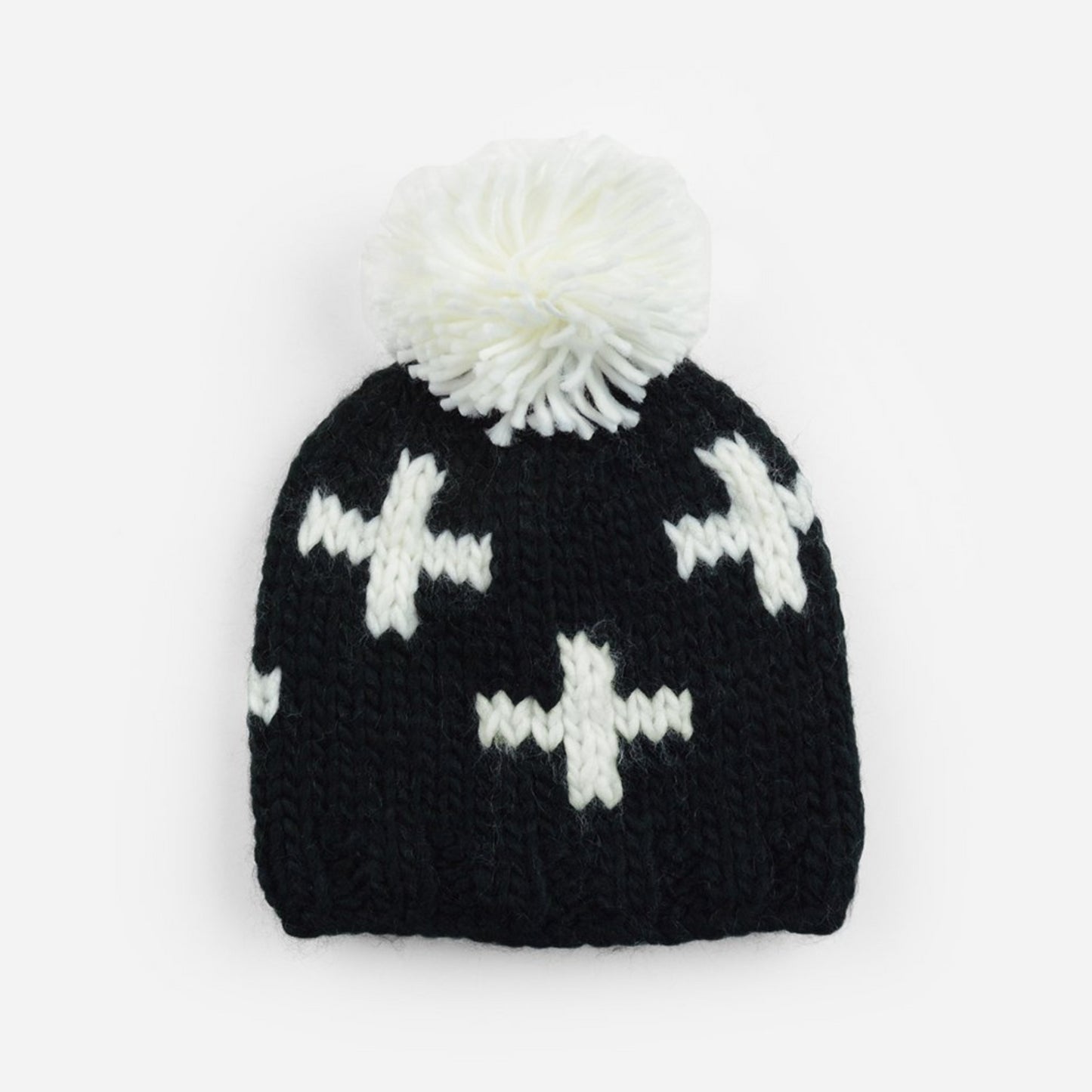 black hand knit beanie with white pom and and swiss cross pattern